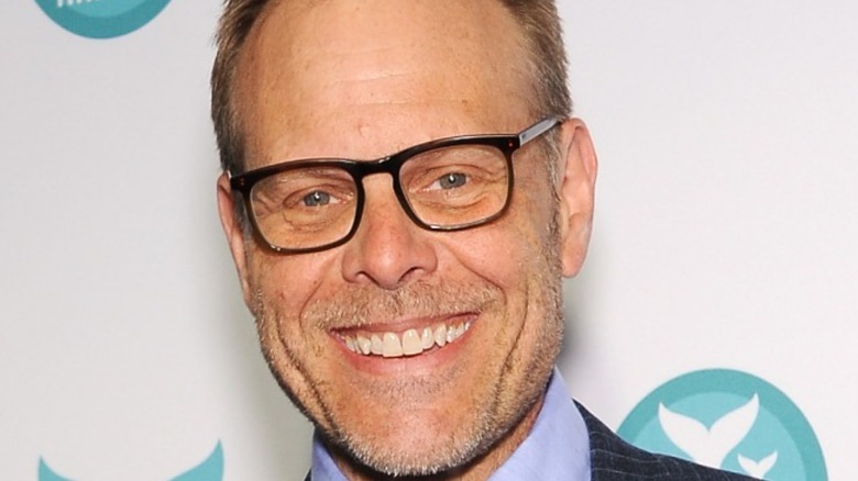Close up of Alton Brown wearing glasses and smiling