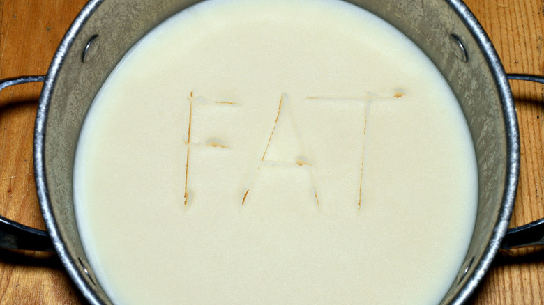 Solidified, white fat in a metal pot, with "FAT" written into it.