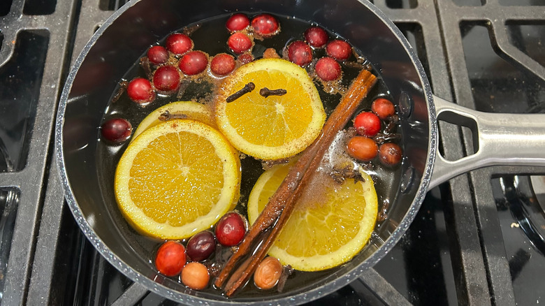 Pot of stovetop potpourri with orange slices, cinnamon, and cranberries