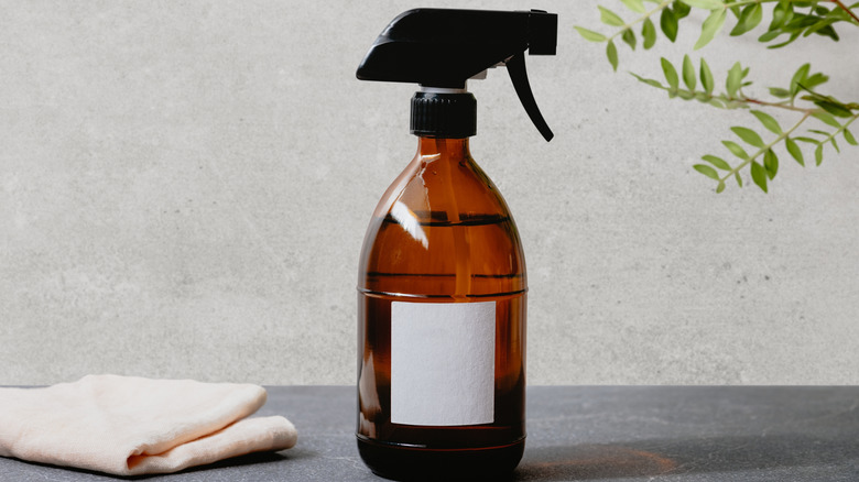 Natural cleaning solution in spray bottle against a gray background