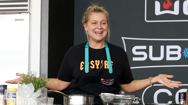 Amanda Freitag smiles with her arms out during a food demo