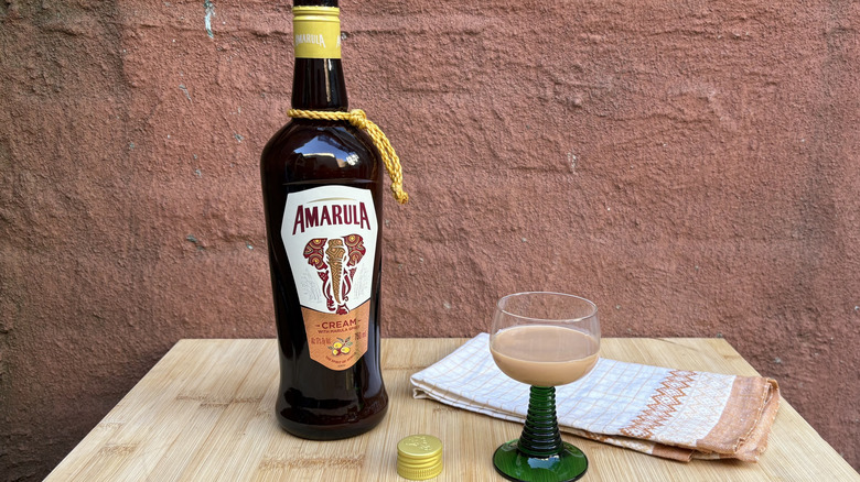 Bottle of Amarula and glass with red background