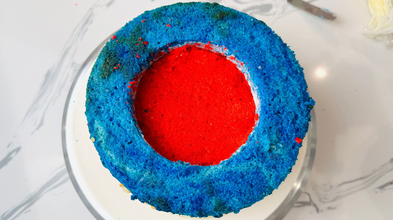 Cake with blue ring on outside and red layer in middle