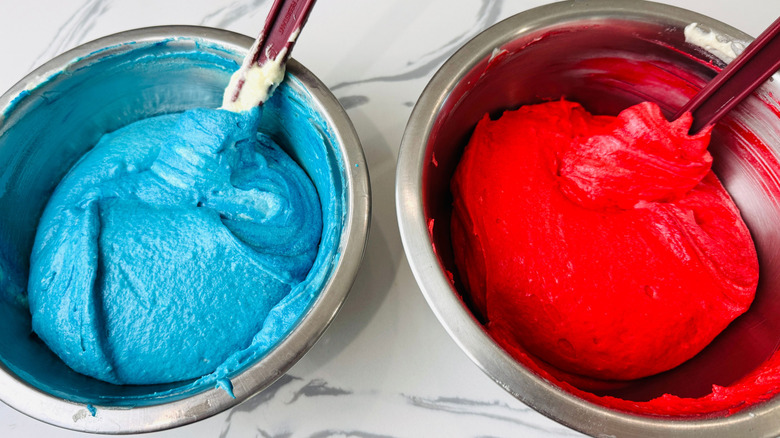 Blue and red cake batter in bowls