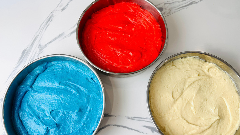 Red, white, and blue cake batter in pans