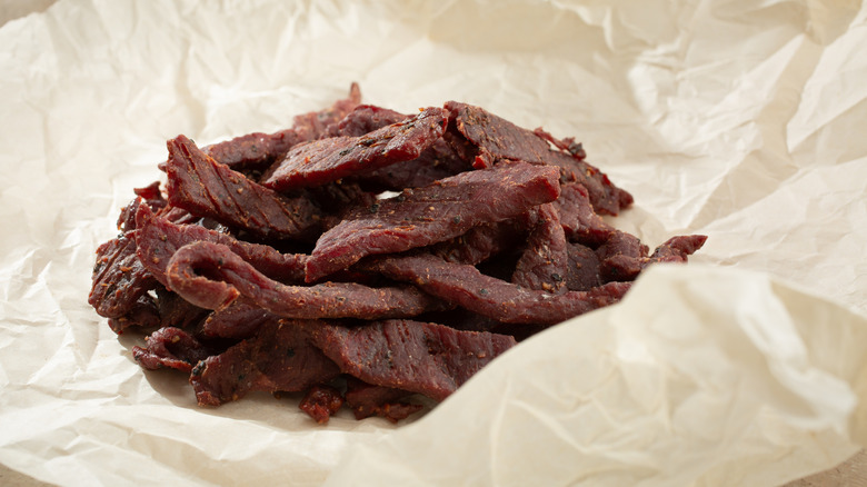 A pile of steak strips wrapped in deli paper