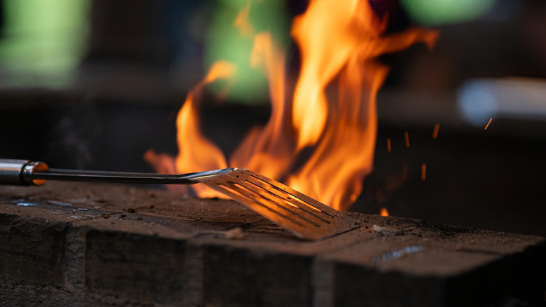 Barbecue spatula in front of a fire