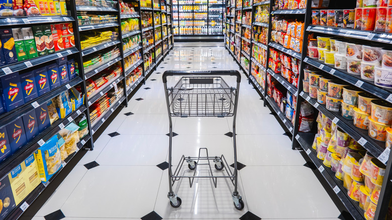Supermarket aisle with empty shopping cart