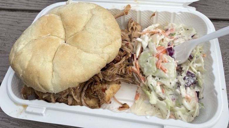 Pulled beef sandwich in a white container with coleslaw