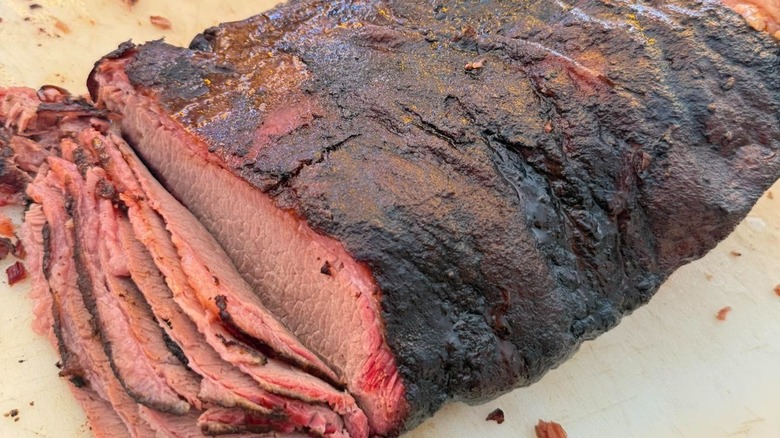 Whole brisket getting sliced on a board