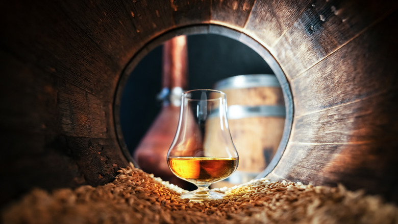 Whiskey glass on grain inside barrel