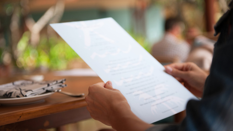 diner reading restaurant menu