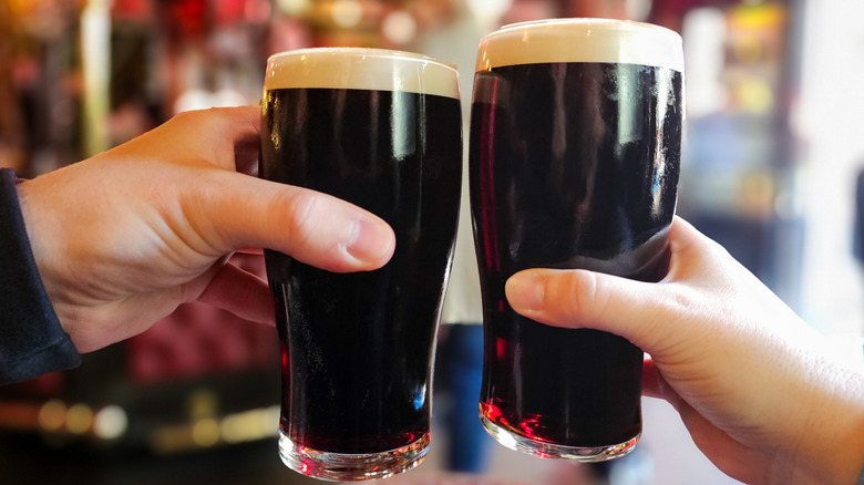 Two hands with stout beer pints
