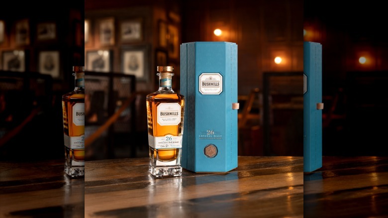 a bottle of Bushmills 26 year old crystal malt whiskey on a wooden table
