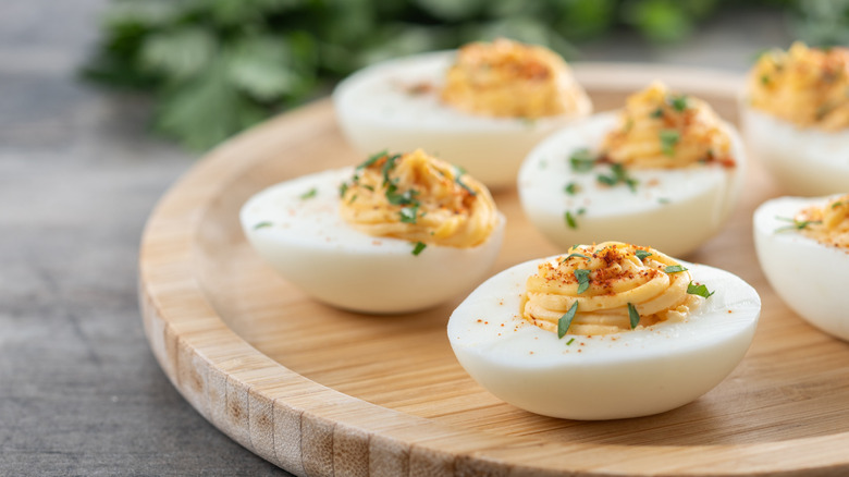 Homemade deviled eggs garnished with herbs.