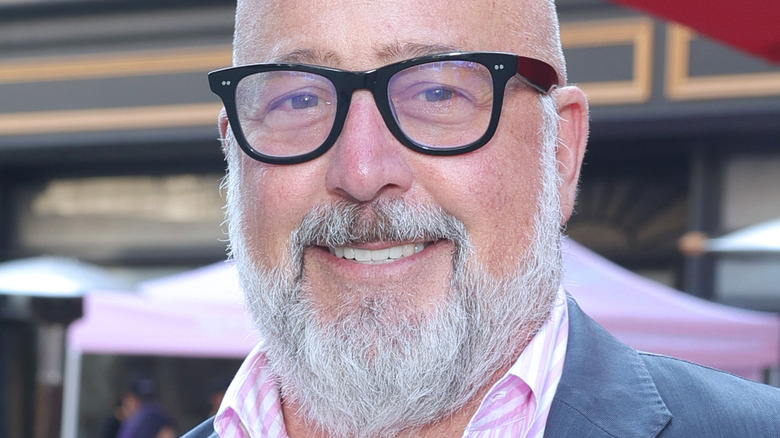 Andrew Zimmern smiles with glasses