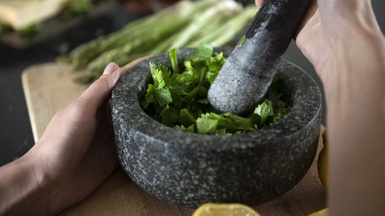 grinding herbs with mortar and pestle