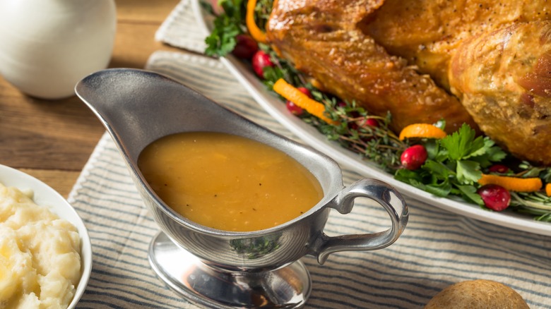 A metal pitcher of turkey gravy
