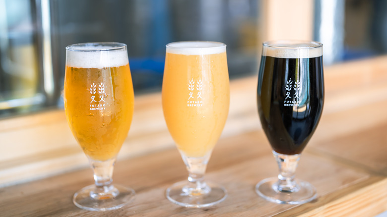 Three glasses of craft beer on a wooden bar