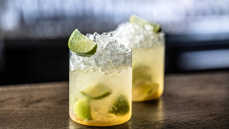 Caipirinha cocktails served with ice in two glasses.