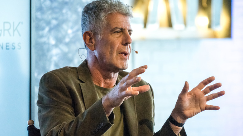 Anthony Bourdain talking with a microphone