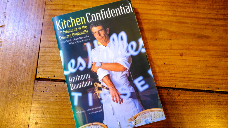 a copy of Anthony Bourdain's "Kitchen Confidential" on a wooden table