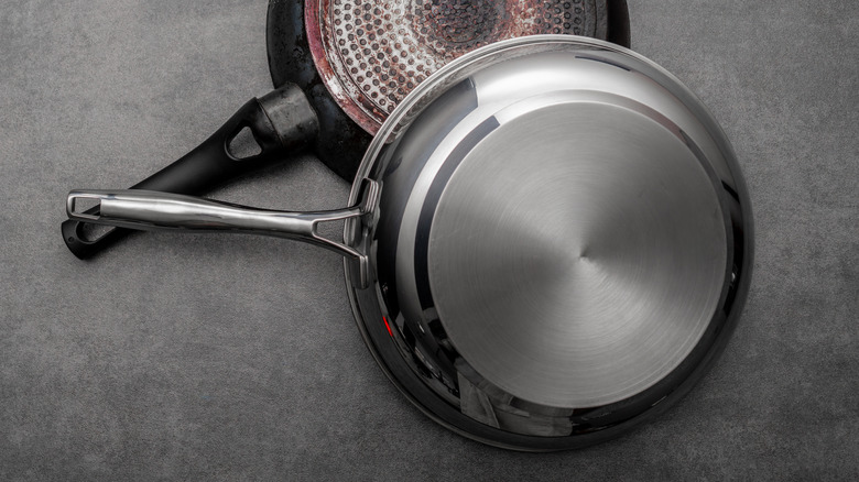 Two pans, one lighter with plastic handle and one thicker and fully steel