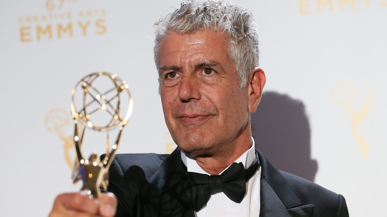 Anthony Bourdain posing with Emmy award