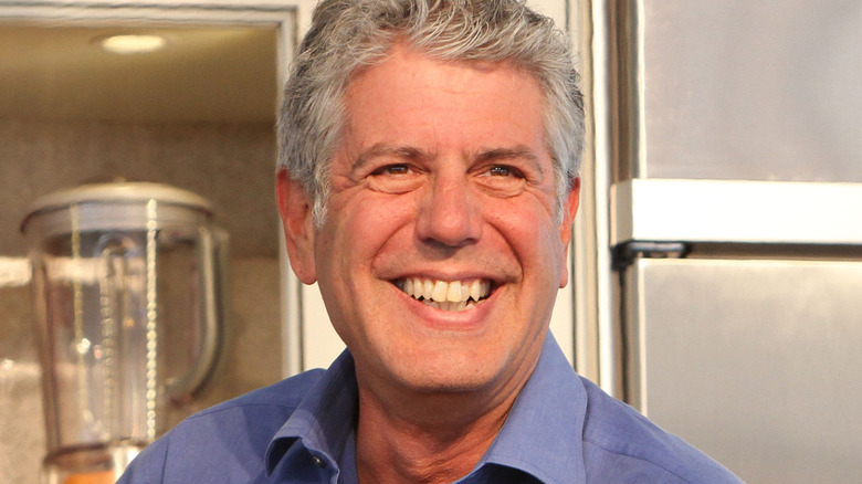 Anthony Bourdain smiling in blue shirt