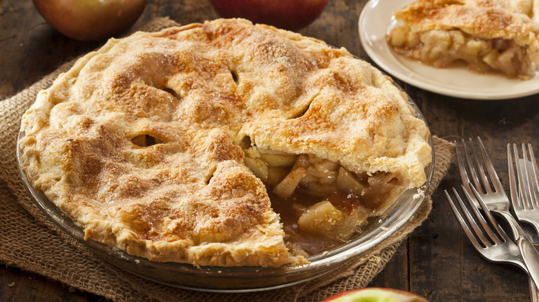 a homemade apple pie with a slice cut out and the filling visible