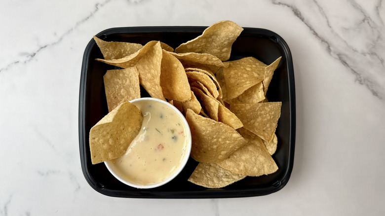 Applebee's white queso dip and chips in a to-go container