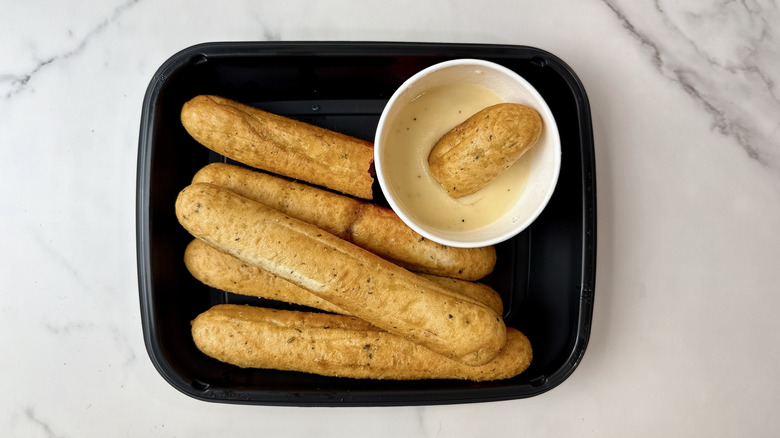 Applebee's breadsticks and Alfredo sauce in a to-go container