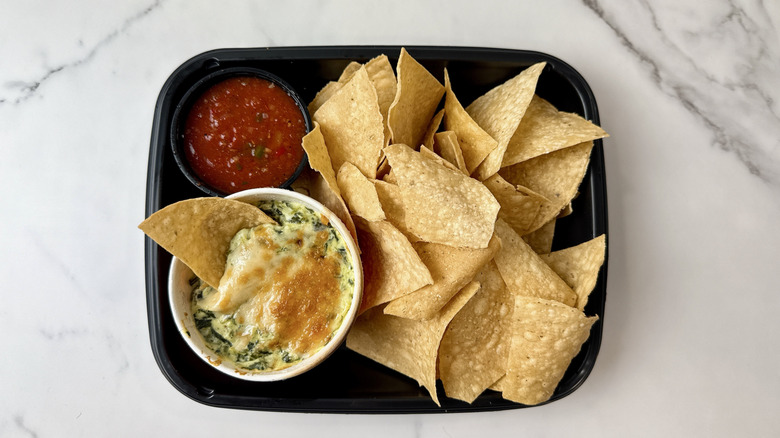 Applebee's spinach and artichoke dip, salsa, and chips in a to-go container
