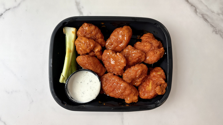 Applebee's boneless wings, celery, and ranch dip in a to-go container