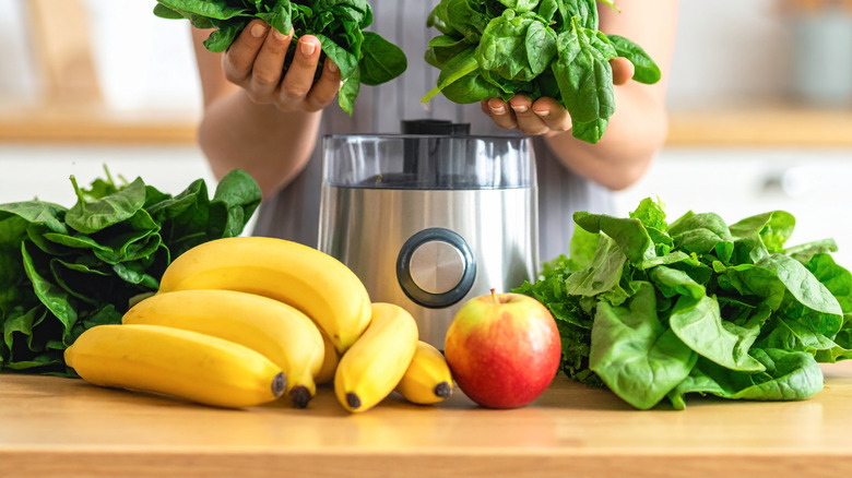 Apples and bananas with greens and smoothie maker