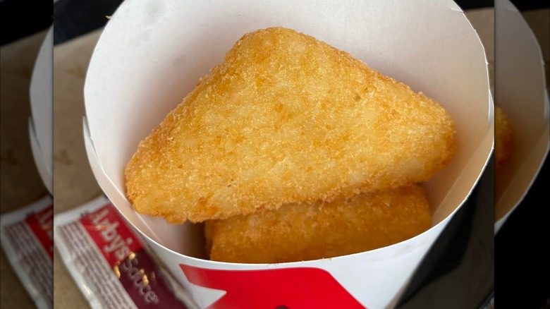 Two potato cakes sitting in Arby's cup