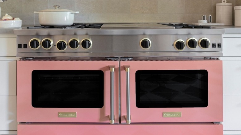 A pink BlueStar cooking range in a kitchen.