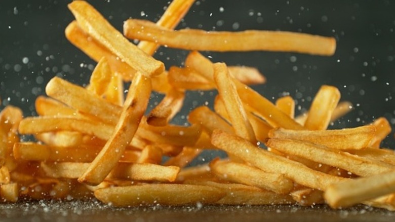 French fries and salt falling on a table