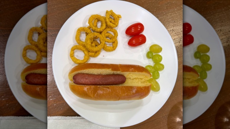 Tiny hot dog on white plate