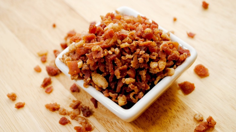 A white bowl overflowing with bacon bits