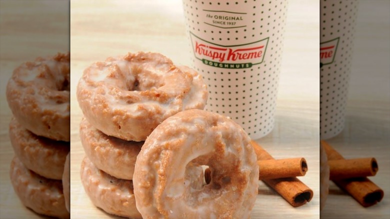 Krispy Kreme pumpkin cake doughnuts with cup and cinnamon stick