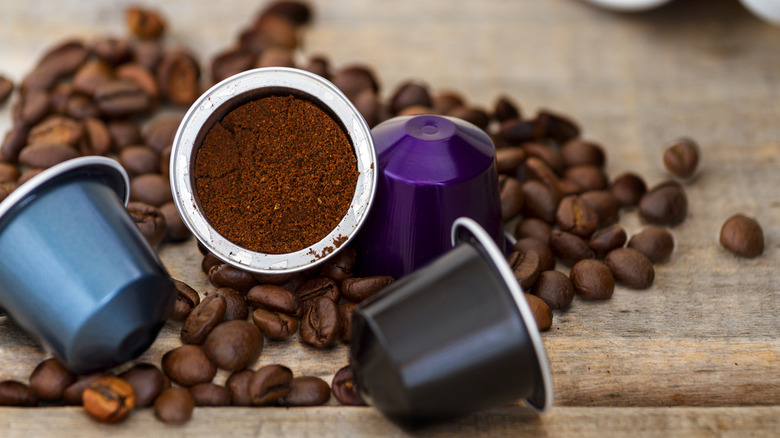 Nespresso pods sitting on coffee beans