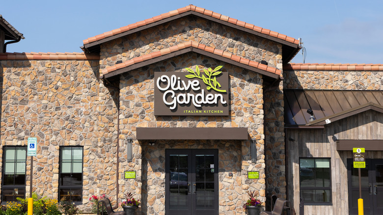 Building with a stone facade displaying a big Olive Garden sign above the entrance