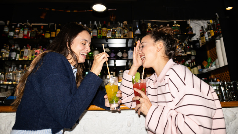 Two friends enjoying drinks in a bar