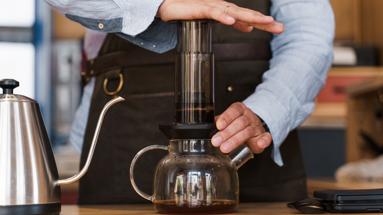 A person making coffee with an AeroPress