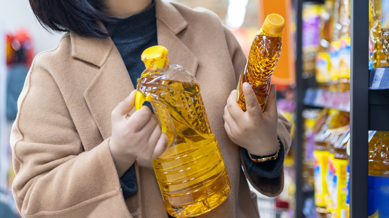 woman comparing cooking oil in the grocery store