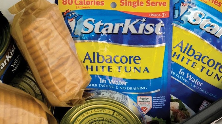 Pouches of StarKist brand albacore white tuna in water next to some cans and sleeves of crackers