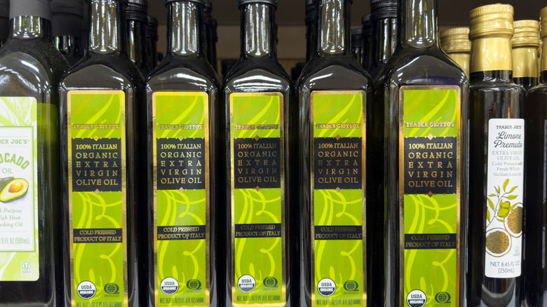 A series of olive oil bottles lined up in a row