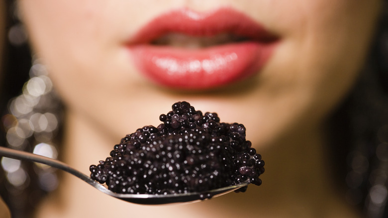 Female mouth spoonful of caviar