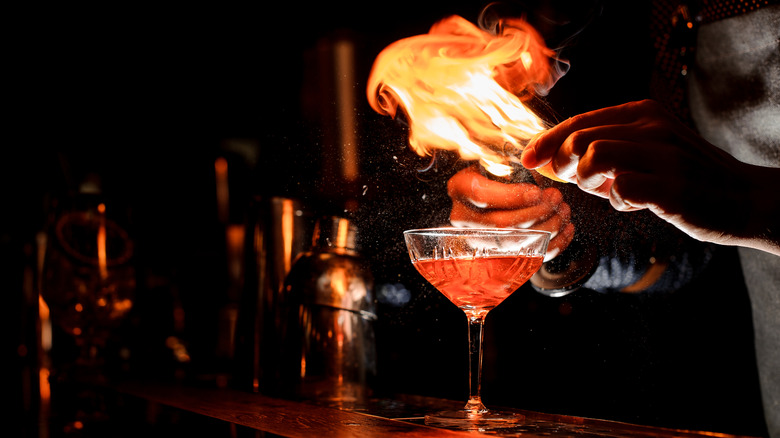 flaming cocktail on dark bartop